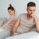 Image of Quarrelled lovely couple sitting separately on couch at home