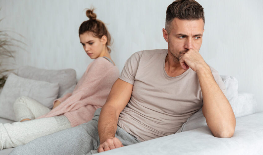Image of Quarrelled lovely couple sitting separately on couch Image of Quarrelled lovely couple sitting separately on couch at home
